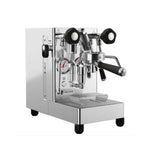 A stainless steel commercial espresso machine with black accents, featuring a portafilter, steam wands, pressure gauge, and drip tray, photographed on a solid white background.