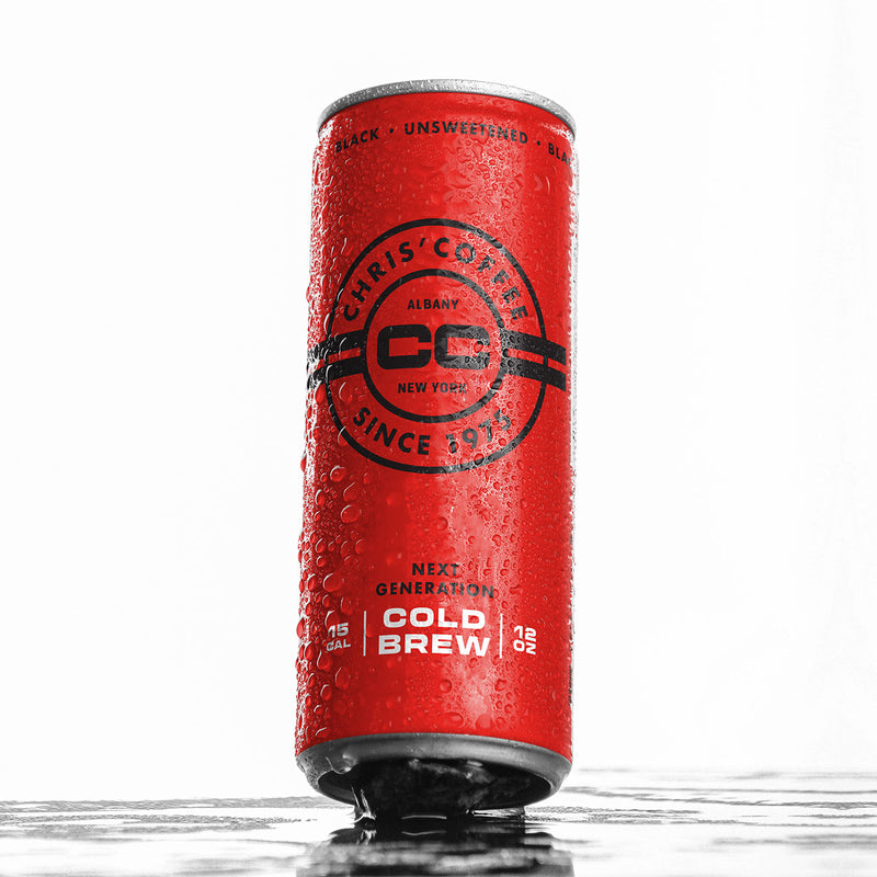 Large red slim cold brew coffee can covered in dew droplets on a white background.