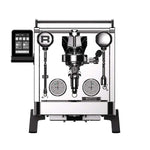 A professional espresso machine with a polished stainless steel body, black accents, dual analog pressure gauges, a digital touch screen control panel on the left, and a central portafilter holder, shown against a solid white background.